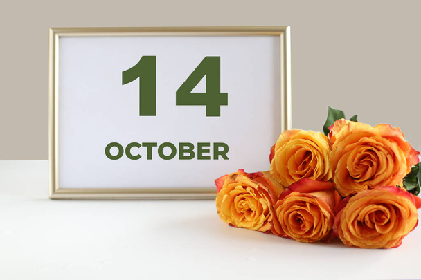 día del mes 14 Octubre calendario marco de fotos y rosa amarilla sobre una mesa blanca. - Foto, Imagen