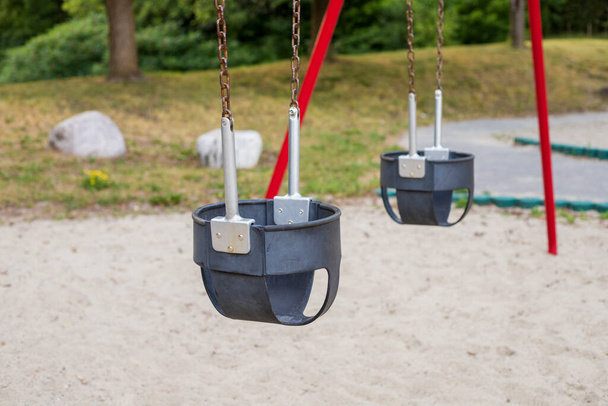 Swings στο πάρκο στην παιδική χαρά μια καλοκαιρινή μέρα χωρίς ανθρώπους - Φωτογραφία, εικόνα