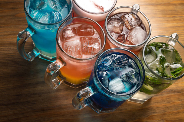 Kleurrijke cocktails op houten ondergrond. Frute alcoholische cocktails. Kleurrijk drankconcept. - Foto, afbeelding
