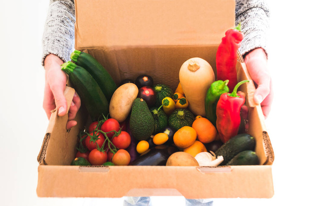futár egy doboz ökológiai gyümölcsök és zöldségek - Fotó, kép
