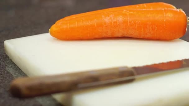 verduras zanahorias en la tabla de cortar blanco en la cocina - Metraje, vídeo