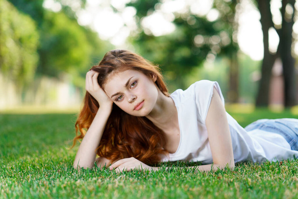 woman lies on the grass in the park outdoors charm leisure nature - Foto, Imagen