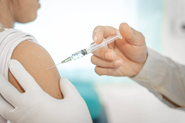 Nahaufnahme Arzt hält Spritze zur Injektion an den Patienten in der medizinischen. Covid-19 oder Coronavirus-Impfstoff. Virusentfernung und Präventionskonzept. - Foto, Bild