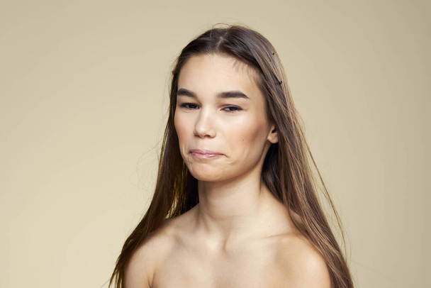 Pretty woman naked shoulders long hair body care beige background - Фото, зображення