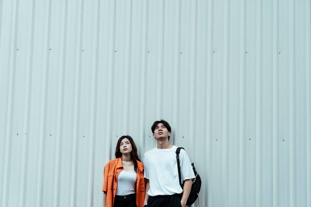 Εφηβικό ζευγάρι στέκεται στο λευκό τοίχο ως μοντέλο μόδας. - Φωτογραφία, εικόνα
