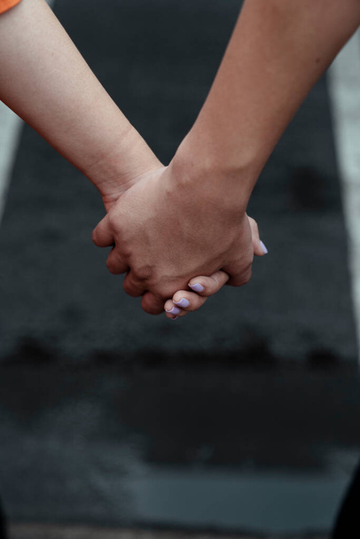 Cropped image of couple's holding hand on the road. - Photo, Image