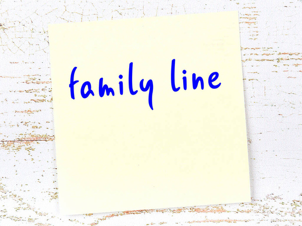 Żółta, lepka nuta na drewnianej ścianie z odręcznie napisaną linią rodzinną - Zdjęcie, obraz