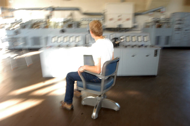 työntekijä liikkuu tuolilla analogisessa ohjaushuoneessa, liikkeen hämärtyminen - Valokuva, kuva