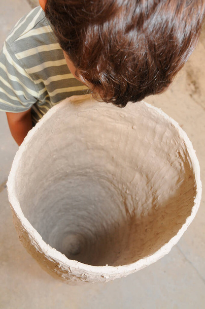 ребенок смотрит в большой горшок вазы, керамики курс для детей - Фото, изображение