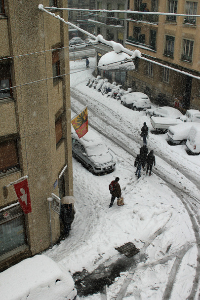 wandelaars in de straat met auto's bedekt met sneeuw door sneeuwt en koud weer, Genève, Zwitserland - Foto, afbeelding