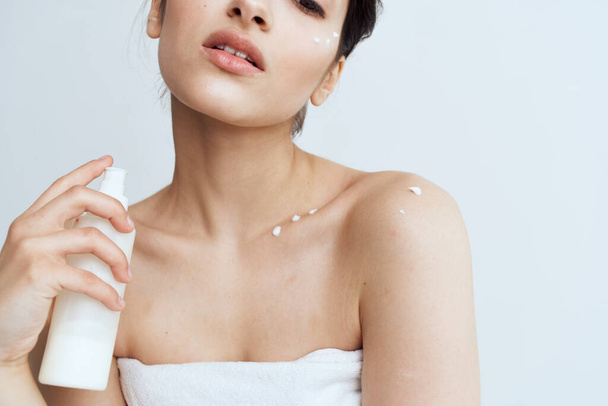 Pretty woman in white towel naked shoulders lotion clean skin hygiene - Foto, afbeelding