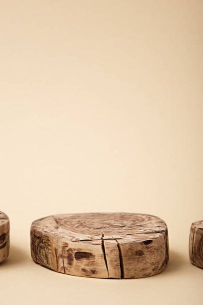 plataforma de madera redonda abstracta sobre fondo beige, escaparate vacío para la presentación de productos cosméticos, pedestal, maqueta, espacio de copia, vertical - Foto, Imagen