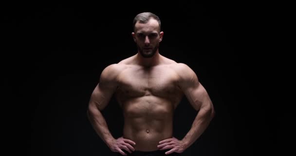 Man flexing muscles in studio - Video