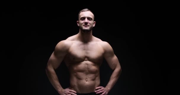 Muscular man posing with arms akimbo - Video, Çekim