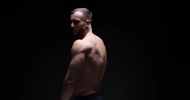 Muscular man posing with arms akimbo - Filmati, video