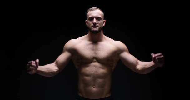 Man flexing biceps in studio - Felvétel, videó