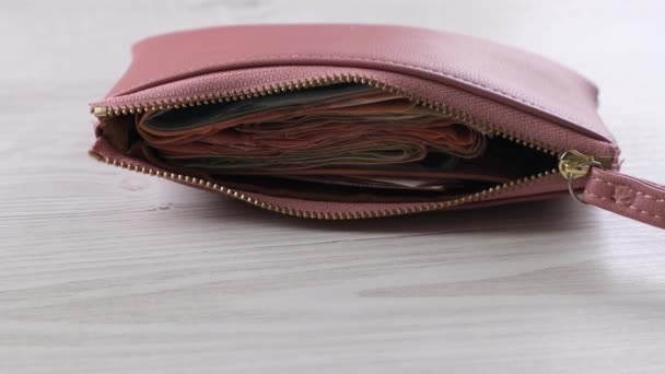 Das Portemonnaie liegt auf dem Tisch neben der Münze. Finanzen, Ertrags- und Aufwandskonzept, Barauszahlung. - Filmmaterial, Video