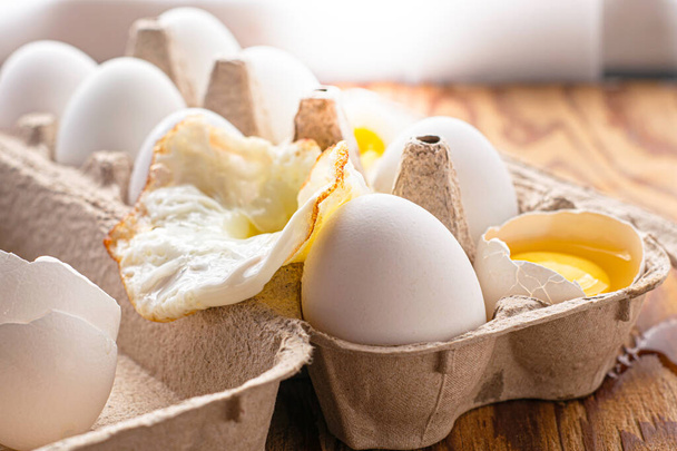 jaja w pudełku tekturowym na stole niektóre jajka są całe inne są w różnym stopniu gotowe. Wysokiej jakości zdjęcie - Zdjęcie, obraz