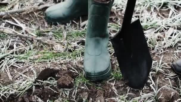 The farmers legs in green rubber boots on. Gardening outfits, autumn rubber footwear. - Footage, Video