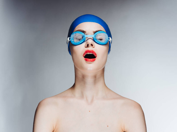 Açık ağızlı ve yüzme gözlüklü kırmızı dudaklı bir kadın. - Fotoğraf, Görsel
