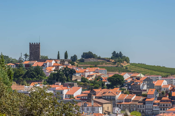 Lamego / Portugalsko - 07 25 2019: Pohled na centrum města Lamego a jako pozadí věž na zámku Lamego, ikonická památková budova na vrcholu města, portugalské dědictví - Fotografie, Obrázek