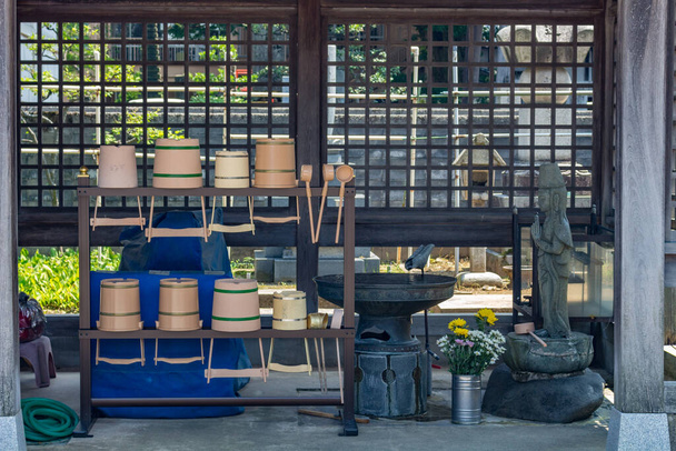 Rack tartalmazó hagyományos vízgyűjtők, vagy sukubai, és merőkanál, vagy hishaku, használt japán szentélyek. Kanazawa, Japán. - Fotó, kép
