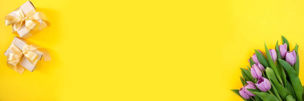 Tulipanes sobre fondo amarillo. Concepto floral festivo con espacio de texto limpio. Acostado. Vista desde arriba. Banner. - Foto, imagen