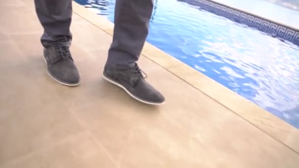 Πόδια ενός άνδρα που περπατούσε κατά μήκος της πισίνας, κοντινό πλάνο - Πλάνα, βίντεο