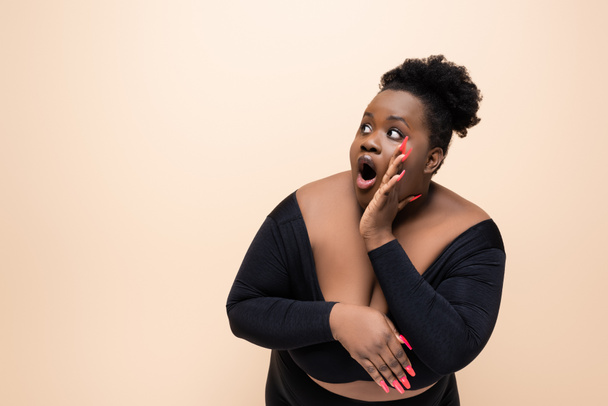 surprised african american plus size woman looking away isolated on beige  - Photo, Image