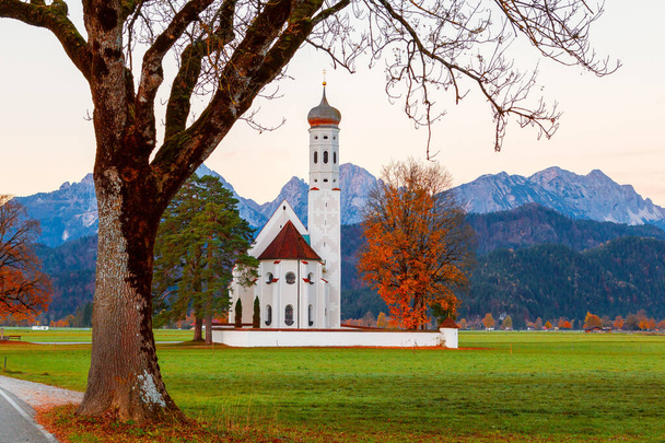 Neuschwanstein kalesi yakınlarındaki Saint Coloman Kilisesi 'nin güzel manzarası, Almanya' nın Bavyera eyaletindeki Schwangau dağlarının arka planına karşı. - Fotoğraf, Görsel