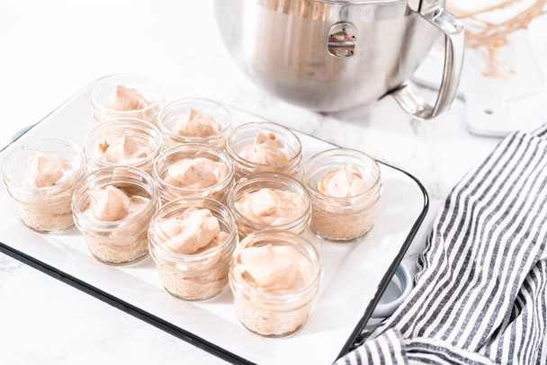 Mélange à ramasser dans les petits pots en verre pour faire de la crème glacée au chocolat maison. - Photo, image