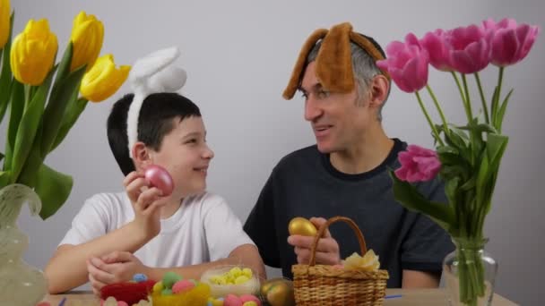 Família feliz. Pai e filho pintam ovos. Páscoa. 4K - Filmagem, Vídeo