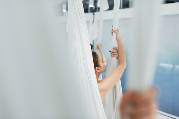 enfoque selectivo de la mujer joven que practica yoga con mosca en primer plano borroso - Foto, imagen