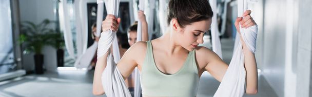 treinamento de mulher esportiva com mosca ioga rede no fundo borrado, banner - Foto, Imagem