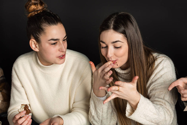 meninas lamber seus dedos enquanto come sobremesas de creme de chocolate - Foto, Imagem