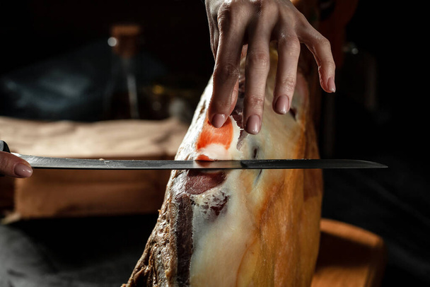 Суха іспанська шинка, Iberian ham cutter на чорному тлі. Іберійський бовдур. Традиційна іспанська шинка. - Фото, зображення