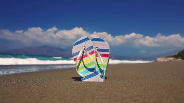 Sandalias de colores en la arena en la playa de Tympaki, Creta, Grecia - Imágenes, Vídeo