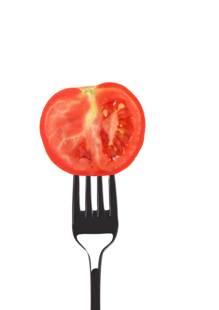 Red ripe tomato on fork. - Zdjęcie, obraz