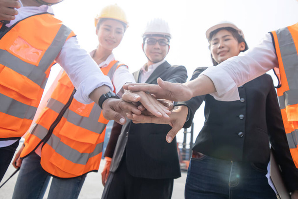 Trabalhadores asiáticos de contêineres se juntam à mão para colaboração após uma reunião - Foto, Imagem
