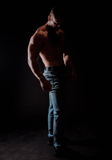 Handsome muscular male model bodybuilder preparing for fitness training.Studio shot on black background - Foto, imagen