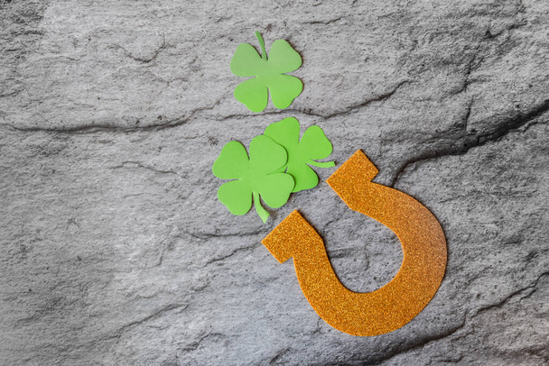 gouden handgemaakte hoefijzer op een grijze achtergrond. feest van St. Patrick - Foto, afbeelding