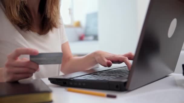 Интернет-магазины. Женщина держит кредитку и делает оплату на ноутбуке. Концепция электронной коммерции. - Кадры, видео