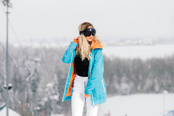 Joven mujer sonriente deportiva en invierno con snowboard, gafas - Foto, Imagen