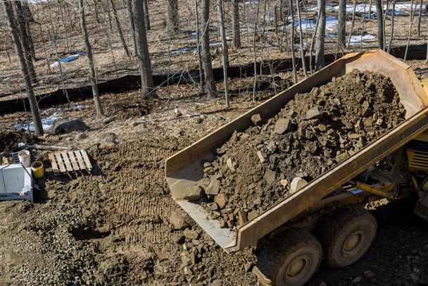 Útépítési autópálya út szemétszállító teherautó lerakja a rakomány kő és talaj építési projekt - Fotó, kép