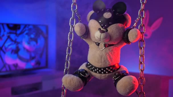 Teddybär hängt in Neonlicht an Ketten - Filmmaterial, Video