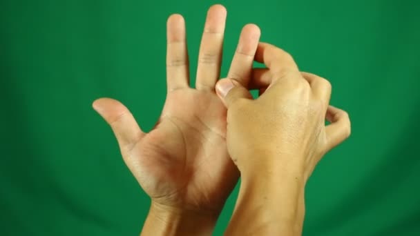 Hombre masajeando sus manos en el estudio - Imágenes, Vídeo
