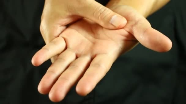 Egy férfi masszírozza a kezét a stúdióban. - Felvétel, videó