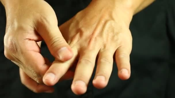 Hombre masajeando sus manos en el estudio - Metraje, vídeo
