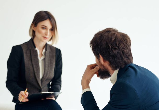 Frau und Mann in einer Jacke auf einem hellen Hintergrund Bewerbungsgespräch - Foto, Bild