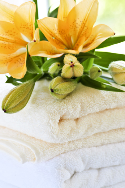 Стопка мягких роскошных полотенец со свежими цветами
 - Фото, изображение